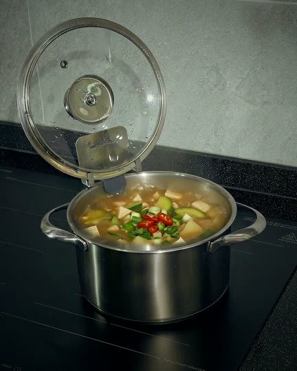 끓는 찌개 옆에 선 뚜껑